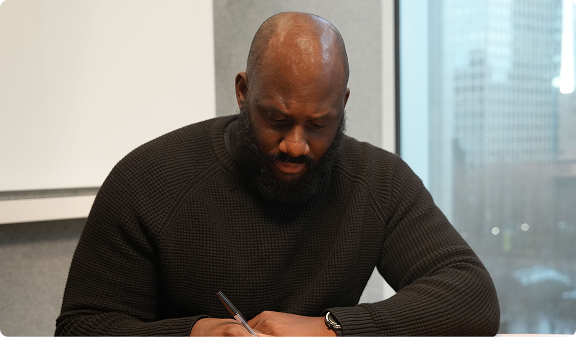 Yoma writing at his desk